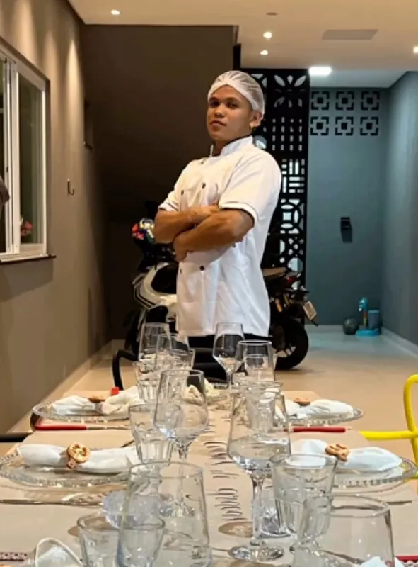 Pizzaiolo da Gold ao lado de uma mesa posta para um jantar